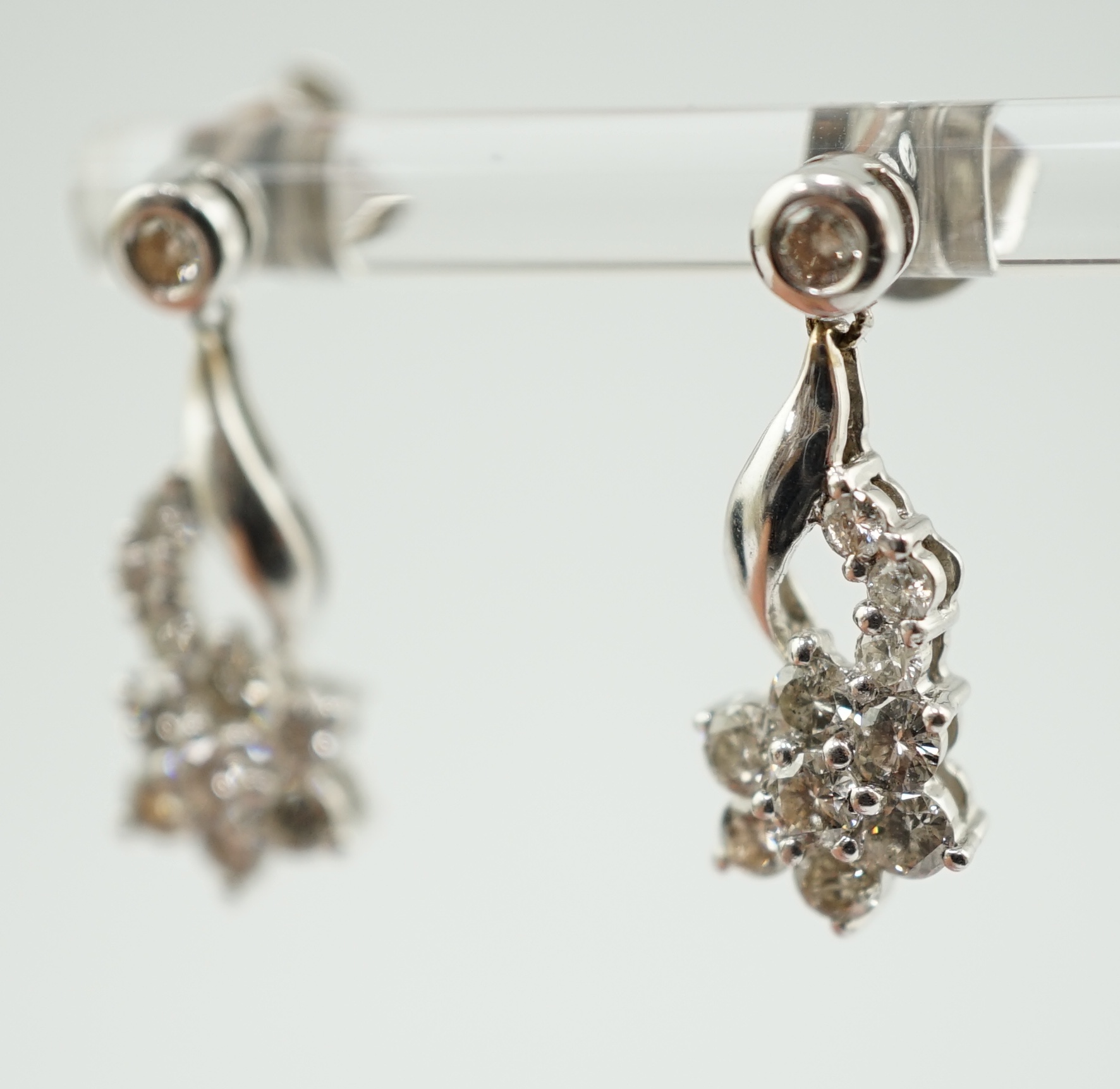 A modern pair of 18k white gold and diamond cluster ear studs, each modelled as a flower with stem